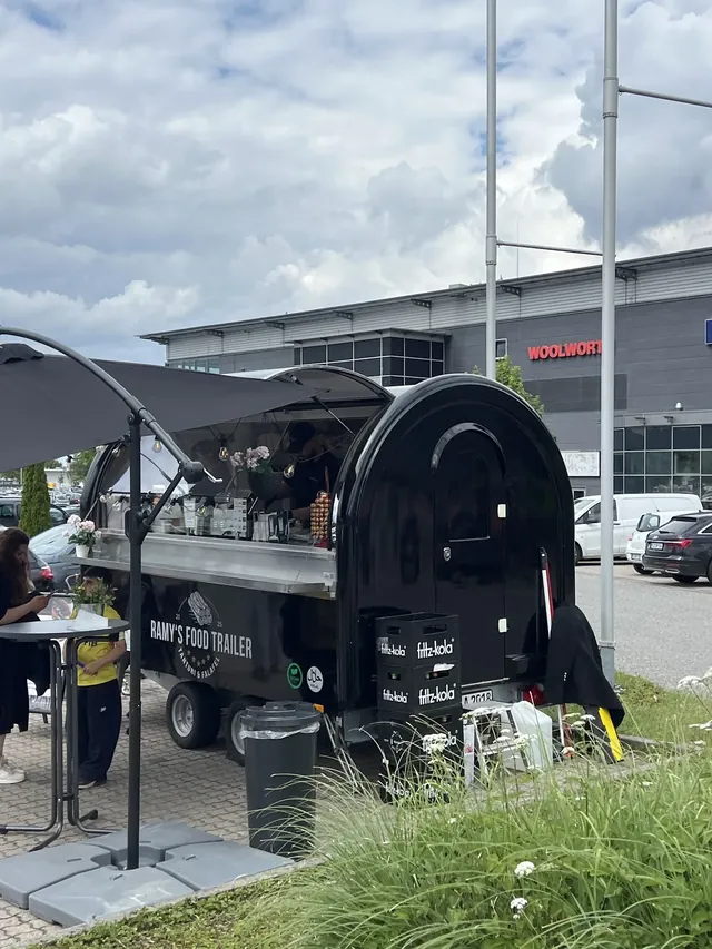 Der Food Trailer bei Tag mit ausgefahrener Markise und Sitzplätzen