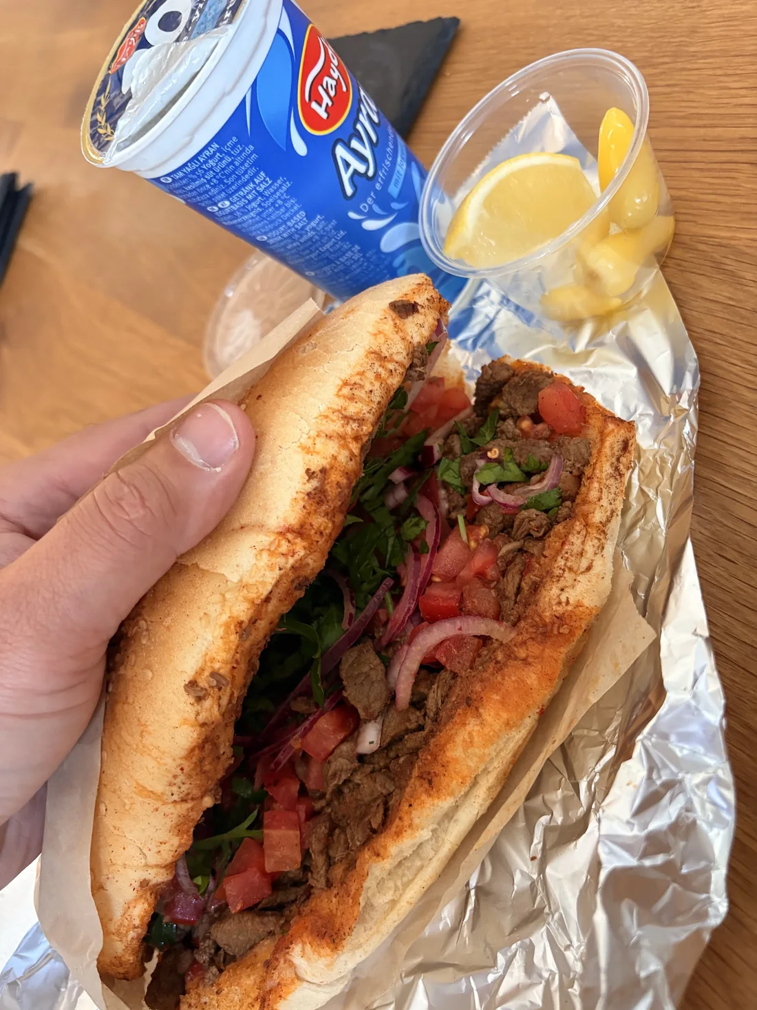 Aufgeschnittenes Tantuni-Sandwich mit Kalbfleisch, Tomate, Zwiebeln und Petersilie
